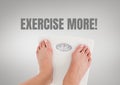 Exercise more text and feet on weighing scales with grey background