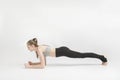 Exercise plank. Young woman doing pilates, working on the abdominal muscles on white background. Girl is engaged. Asana in yoga Royalty Free Stock Photo