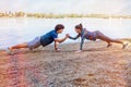 Exercise - Sportswoman and sportsman giving high five to each other while doing push ups Royalty Free Stock Photo