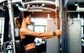 your arms with this arm exercise machine. healthy women exercise in fitness gym