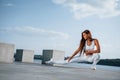 Exercises for legs. Shot of sportive woman doing fitness near the lake at daytime