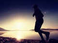 Exercising on the beach at sunset, sun at horizon Royalty Free Stock Photo