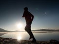 Exercising on the beach at sunset, sun at horizon Royalty Free Stock Photo