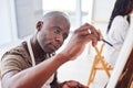 Exercising our creativity gives us an outlet from our daily routines. a middle aged man painting in a art studio.