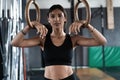 Exercising woman holding gymnast rings. Female taking rest after intense dip ring workout at gym Royalty Free Stock Photo