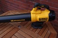 EXETER, DEVON, ENGLAND - SEPTEMBER 23RD 2020: Dewalt 18 volt cordless leaf blower rests on a garden table ready to be put to use