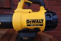 EXETER, DEVON, ENGLAND - SEPTEMBER 23RD 2020: Dewalt 18 volt cordless leaf blower rests on a garden table ready to be put to use