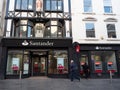 EXETER, DEVON, UK - December 03 2019: Santander bank branch on Exeter High Street with a pedestrian walking by and a customer usin Royalty Free Stock Photo