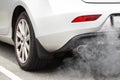 Exhaust pipe of a car - blowing out the pollution from the back of a white car Royalty Free Stock Photo