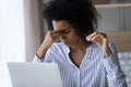 Exhausted African American young woman taking off glasses close up