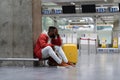 Exhausted African man on a long night connection at airport, waiting for a plane sitting in terminal Royalty Free Stock Photo