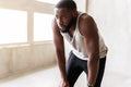 Exhausted african well-build man having break of exercise Royalty Free Stock Photo