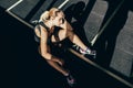 Exhausted athletic sportswoman with hand on her forehead sitting on floor