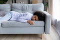 Exhausted biracial woman sleep on couch at home