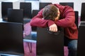 Exhausted boy holding glasses and sleeping in meeting room Royalty Free Stock Photo