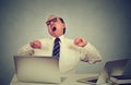 Exhausted business man yawning at work in office sitting at his desk with laptop computers Royalty Free Stock Photo