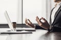 Exhausted businessman meditating in office. Tired men relaxing and doing yoga during work. Male hands in mudra close up view.