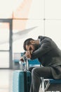 exhausted businessman sleeping at airport lobby while waiting Royalty Free Stock Photo