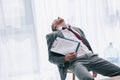 exhausted businessman sleeping on chair with contract in hand Royalty Free Stock Photo