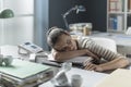 Exhausted businesswoman sleeping on her desk