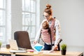 Businesswoman with her baby son working with documents at the office Royalty Free Stock Photo