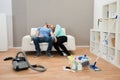 Exhausted couple on sofa in living room