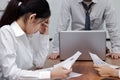 Exhausted depressed young Asian business woman with hands on face suffering from severe problem between meeting in office.