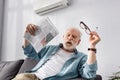 Exhausted elderly man holding newspaper and