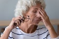 Exhausted elderly woman suffer from blurry vision