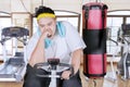 Exhausted fat man doing workout with exercise bike Royalty Free Stock Photo