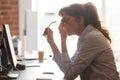 Tired female employee suffer from headache at workplace
