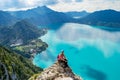 Exhausted but happy climbing girl taking a break on a rock cliff above the turquise waters of Attersee lake, Austria Royalty Free Stock Photo
