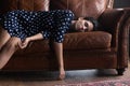 Exhausted Hispanic woman resting on comfortable leather couch at home