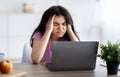 Exhausted Indian teen girl suffering from headache, having migraine, overworking, having too much online homework Royalty Free Stock Photo