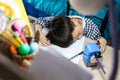 Exhausted kindergarten student is sleeping under the lamp on the desk,Tired kid boy fallen asleep on his book while doing homework Royalty Free Stock Photo