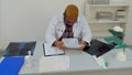 Exhausted male doctor falling alseep over medical papers at his desk