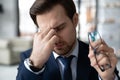 Exhausted male employee suffer from headache at workplace