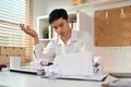 Exhausted male employee working with annual financial report at his workplace. Failure business, overwork concept