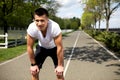 Exhausted male is having break during running in park