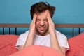 Exhausted man suffering from a headache in his bedroom Royalty Free Stock Photo