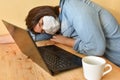 Exhausted masked woman fell asleep while working on laptop at home Royalty Free Stock Photo