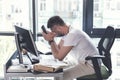 Exhausted mature employee is sitting at desk