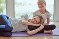 An exhausted mother is lying on her daughter after heavy yoga classes and smiling. cute and beautiful sports family