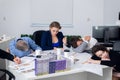 Exhausted office workers resting on their workplace, while havin Royalty Free Stock Photo