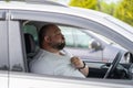 Exhausted overweight man driver feels blood pressure sitting inside car hot weather in traffic jam