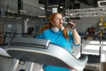 Exhausted overweight woman drinking water taking break during training on treadmill