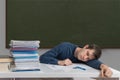 Exhausted and overworked teacher is sleeping on desk in classroom Royalty Free Stock Photo