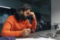 Exhausted overworked young indian man at dark office Royalty Free Stock Photo