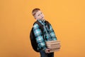 Exhausted schoolboy with backpack holding heap of books Royalty Free Stock Photo