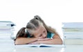 Exhausted schoolgirl falling asleep on her books after studying too much Royalty Free Stock Photo